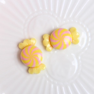 Macro shot of colorful resin candy accessories with spiral patterns on a ceramic plate