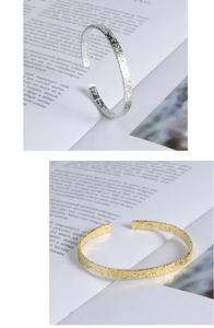 Detail view of silver and gold cuff bracelets with a hammered metal texture finish