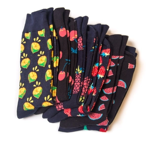 Close-up of neatly stacked crew socks with colorful lemon, cherry and fruit patterns