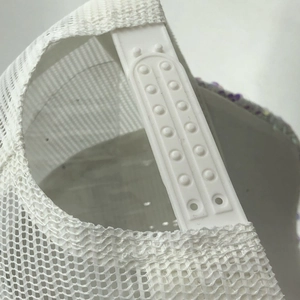 Detail of adjustable white snapback closure and breathable mesh on a trucker hat