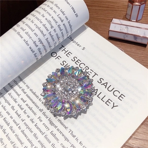 Macro shot of sunflower brooch with crystal inlays on a magazine background