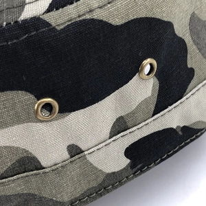 Close-up of camo cotton hat showing metal ventilation eyelets and durable double stitching