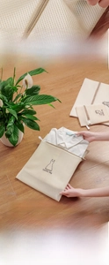 Action shot of placing a white shirt into a fine mesh polyester laundry wash bag