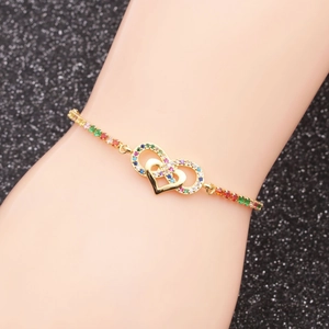 Detail of adjustable gold bracelet featuring double heart motif and colorful zircons