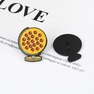 Detailed view of globe-shaped enamel brooch with yellow finish and secure clutch back