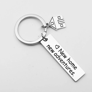 Macro view of a stainless steel house keychain with New Home New Adventures engraving