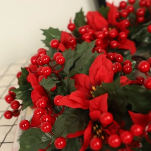 Artificial Christmas wreath with red poinsettia flowers and green holly leaves decoration