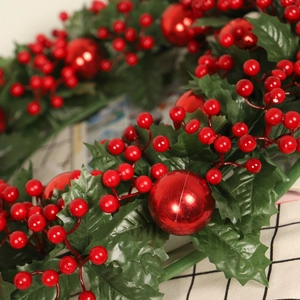 Christmas wreath with green holly leaves and red berries on a rustic plaid background