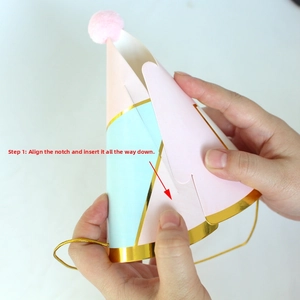 Detail showing the assembly of a pastel party hat with pom-pom and gold trim