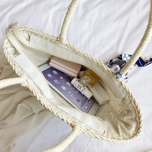 Minimalist straw woven tote bag in off-white showing spacious interior and zipper closure
