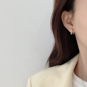 Minimalist square geometric 925 sterling silver earrings worn by a model in profile