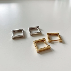 Macro detail of square S925 silver hoop earrings with zircon in gold and silver finish