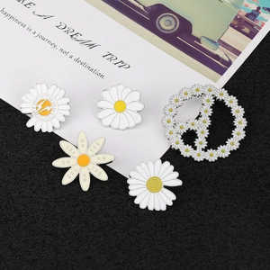 Detailed set of five daisy enamel pins showing white petals and yellow centers on card