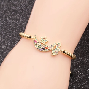 Gros plan d'un bracelet lune et étoile doré avec zircons colorés sur le poignet