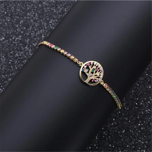 Adjustable gold tree of life bracelet with colorful cubic zirconia on black pedestal