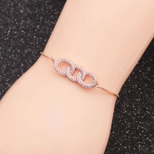 Close-up of rose gold infinity bracelet with zircon stones on model hand