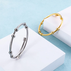 Twisted cable wire bracelet in gold and silver finish with adjustable bead accents