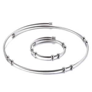 Twisted stainless steel wire necklace and bangle set with silver beads on white background