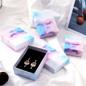 Detailed view of pink and blue watercolor jewelry gift boxes on white fabric
