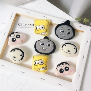 Close-up of assorted plush embroidered character brooches including Crayon Shin-chan and Simpsons
