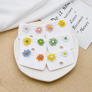 Detail of colorful daisy stud earrings with S925 silver posts on a white tray