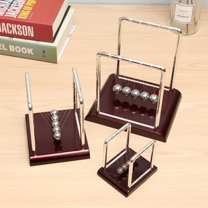 Close-up of polished metal kinetic Newton's Cradle balls in three different sizes