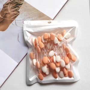Detail of bulk double-sided eyeshadow applicators with orange and white sponge tips