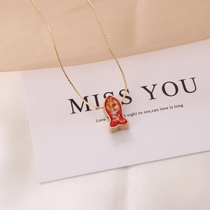 Detailed macro view of a red mermaid fish pendant with gold chain on a gift card