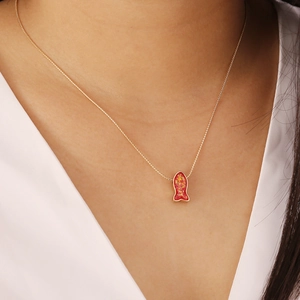 Close-up of a gold chain necklace featuring a red fish pendant with gold foil details