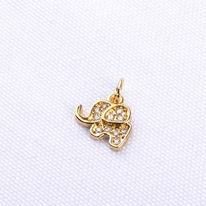 Close-up of golden elephant pendant with sparkling cubic zirconia on textured background