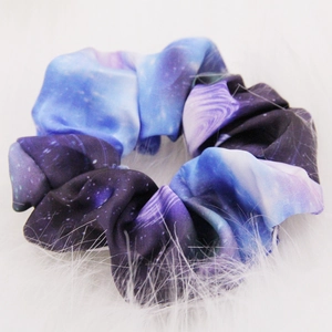 Close-up of starry night pattern scrunchie with purple and blue silk fabric detail