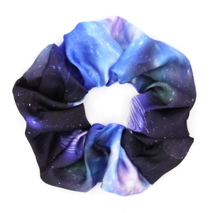 Flat lay of star-themed fabric scrunchie with blue and purple gradient nebula pattern