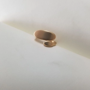 Macro detail of matte 18K gold plated asymmetric oval pea ring with minimalist finish