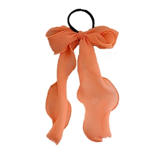Orange fairy-style oversized lace bow hair scrunchie with long ribbons on white backdrop