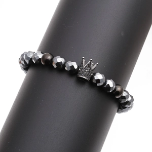 Men's faceted hematite bead bracelet with black crown charm on display stand