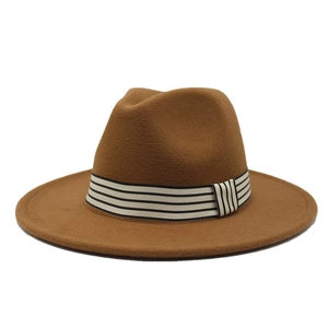 Close-up of the thick tan wool felt texture and black-and-white striped ribbon on the fedora