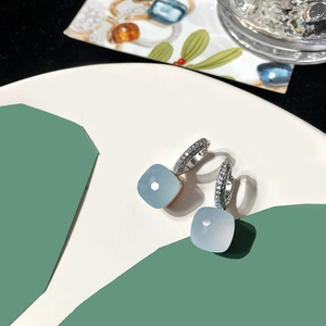 Macro shot of light blue square crystal earrings with pavé-set zircon hoops