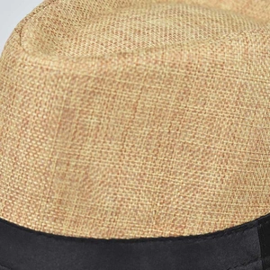 Detailopname van de geweven linnen textuur en zwarte band van een heren fedora hoed.
