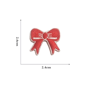 Detailed close-up of a mini red embroidered bow patch with 2.6cm x 2.4cm dimensions