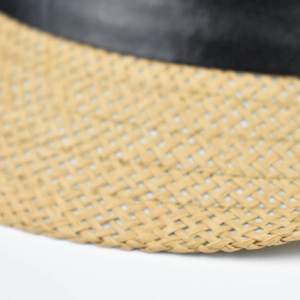 Macro detail of natural straw weave texture with premium black faux leather trim