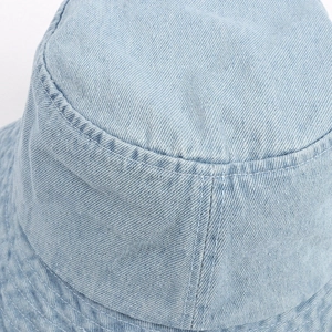 Detailed close-up showing light blue denim texture and neat stitching of the sun bucket hat