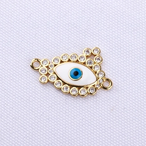Macro detail of gold plated Evil Eye connector with blue enamel and clear zircon stones