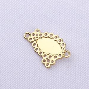 Detailed close-up of gold oval hollow charm with crystals for DIY jewelry making