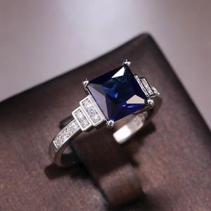 Blue square-cut zircon ring with silver-tone band and side-row pavé setting