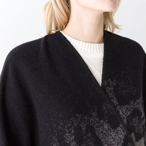 Modern black leopard jacquard poncho shawl with knit texture on a white background