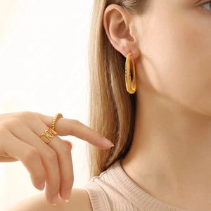 Golden spring spiral hoop earrings and textured ring set shown on elegant model