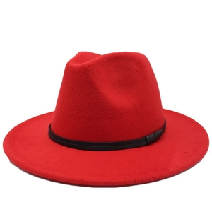 Detail of red fedora hat with a wide brim and decorative black leather band texture