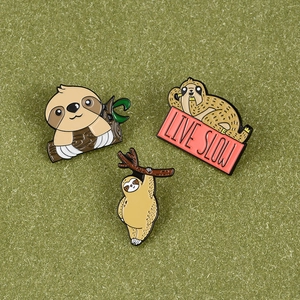 Three cute sloth enamel pins set including Live Slow banner and hanging sloth designs