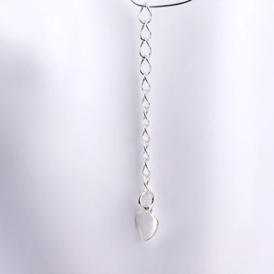 Macro view of S925 silver extender chain featuring a heart-shaped tag and lobster clasp