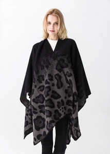Detail shot of leopard print knit poncho with soft texture on a fashion model